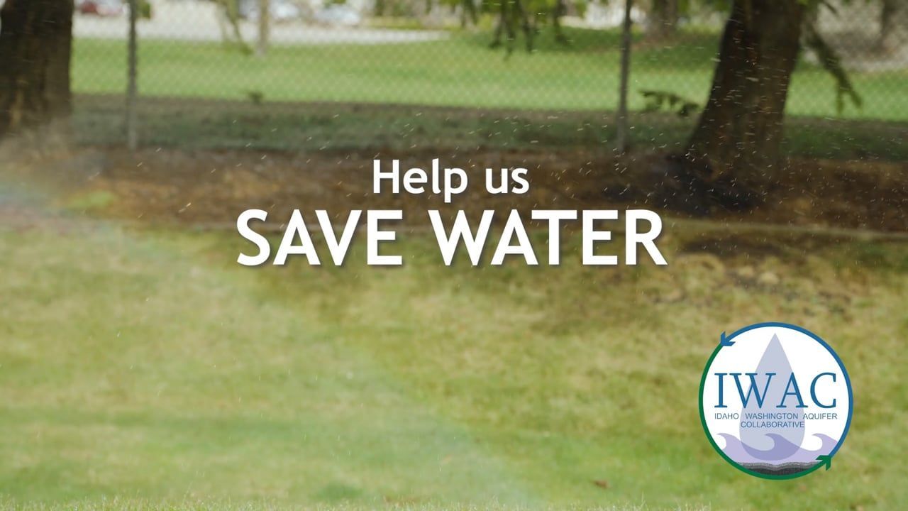 Water sprinklers active on a lawn with the text "help us save water" displayed, alongside the logo of the idaho water awareness campaign.